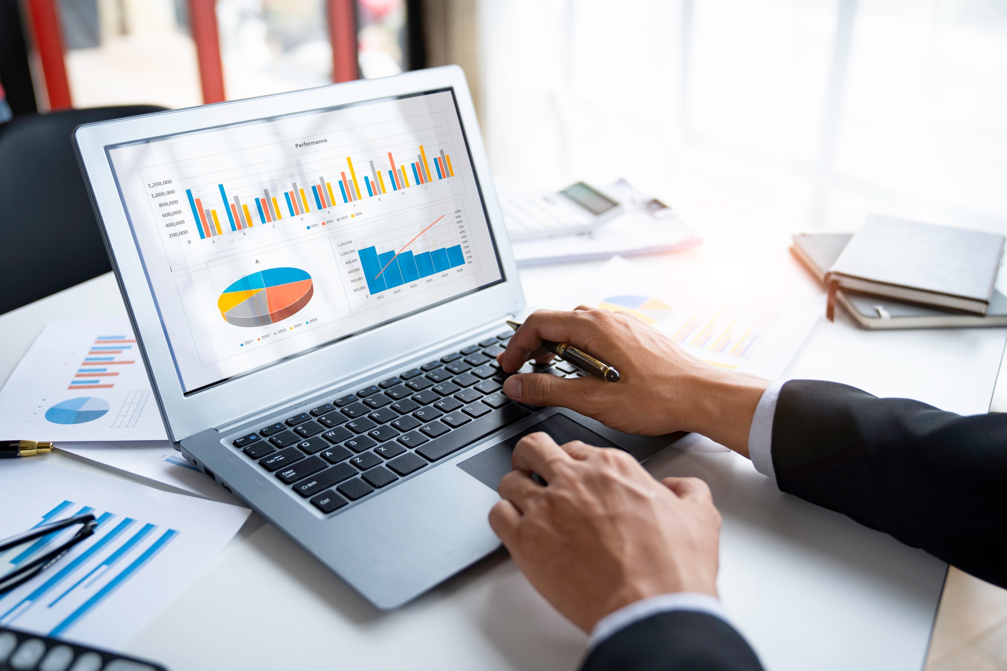 Business professional analyzing digital performance charts on a laptop, reviewing metrics and insights related to SEO content marketing strategy in a corporate setting. 