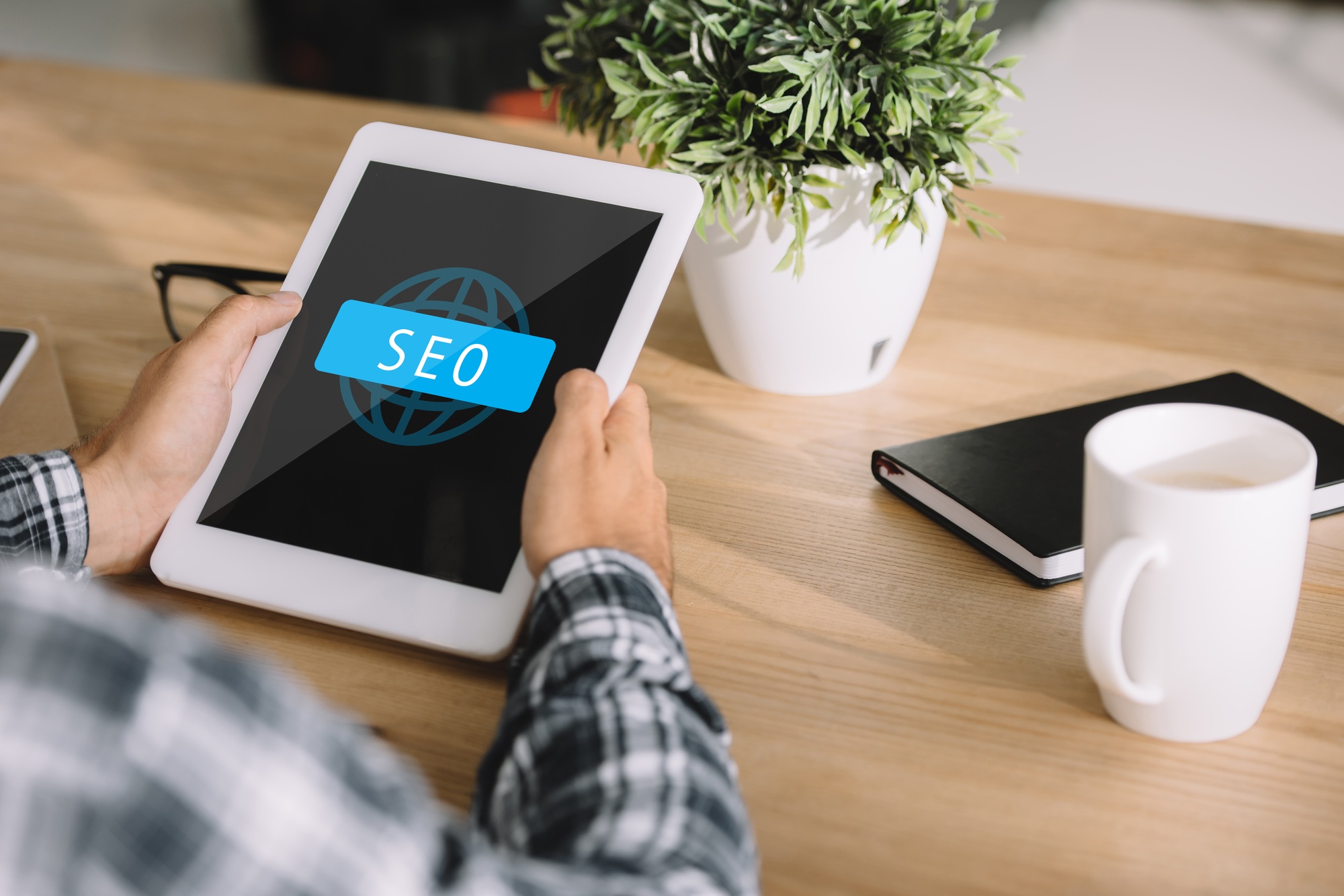 Digital marketer using a tablet with SEO interface on screen, representing the implementation of Orlando SEO tips to improve local search visibility and traffic.